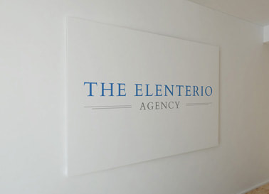 The Elenterio Agency logo printed on a wall